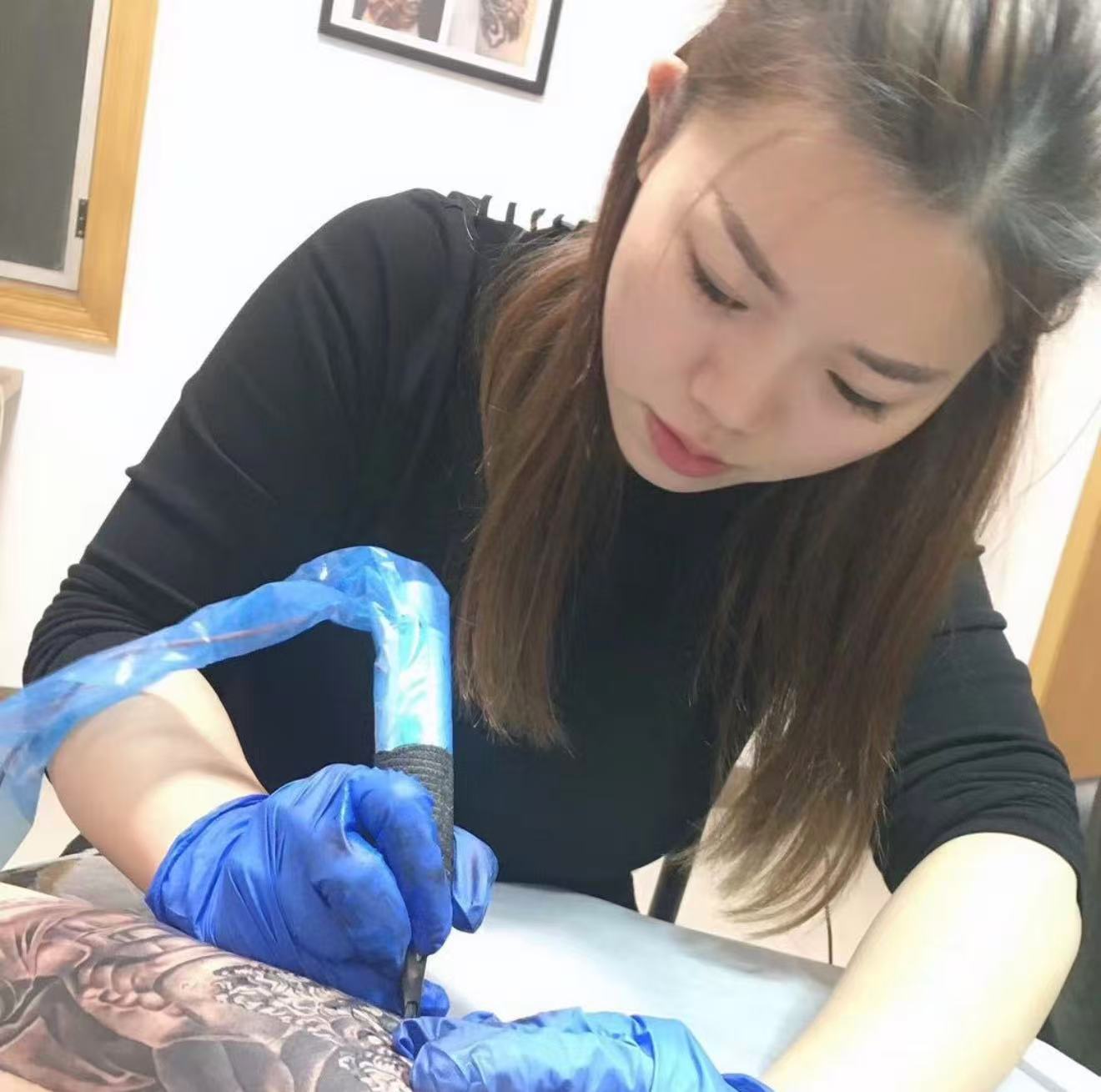 Yao, tattoo artist at Zencat, at work